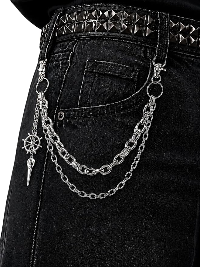 A silver multi-strand wallet chain with decorative charms clipped to the belt loop of black denim jeans